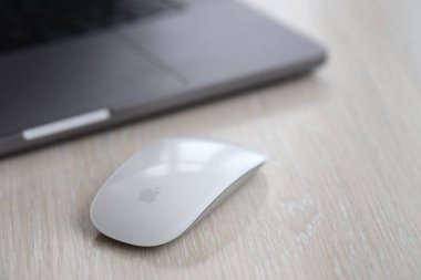 KYIV, UKRAINE - 27 Kasım 2023 Apple Magic Mouse 3. Nesil Gri MacBook 2021 ile yakın plan