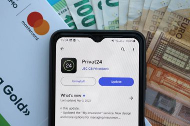 TERNOPİL, UKRAINE - 7 Temmuz 2023 Privatbank yeni bankacılık kartları ve masada para. Privat24 başvurusu kapat