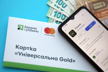TERNOPİL, UKRAINE - 7 Temmuz 2023 Privatbank yeni bankacılık kartları ve masada para. Privat24 başvurusu kapat