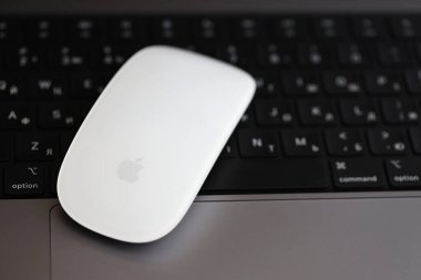 KYIV, UKRAINE - 27 Kasım 2023 Apple Magic Mouse 3. Nesil Gri MacBook 2021 ile yakın plan