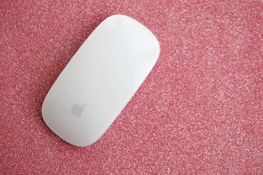 KYIV, UKRAINE - NOVEMBER 27, 2023 Apple Magic Mouse 3rd generation lies on sparkling glitter surface close up clipart