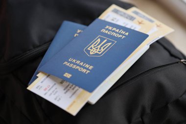 Siyah turistik sırt çantası üzerinde uçuş biletleri olan iki Ukrayna biyometrik pasaportu.