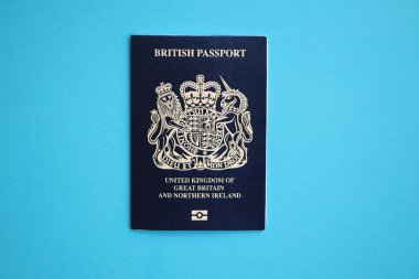 Mavi arkaplanda mavi bir İngiliz pasaportu var. Turizm ve vatandaşlık kavramı