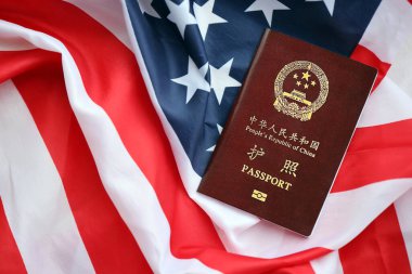 Amerikan bayrağında Çin Halk Cumhuriyeti 'nin kırmızı pasaportu. Parlak arkaplanda PRC Çin pasaportu