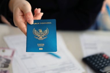 Vatandaşlık kaydı sürecinde Endonezya pasaportu ve servis çalışanları masası. Kadın işçi pasaport veriyor.