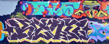 Sokak sanatı kültürü tarzında boya lekeleriyle süslenmiş eski duvar. Duvarında parlak aerosol çizgileri olan graffiti resimlerinin renkli arka planı. Renkli arkaplan dokusu