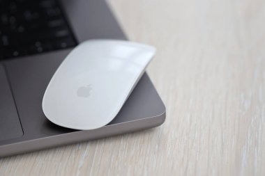 KYIV, UKRAINE - 27 Kasım 2023 Apple Magic Mouse 3. Nesil Gri MacBook 2021 ile yakın plan