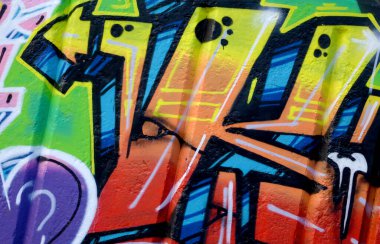 Duvarında parlak aerosol çizgileri olan grafiti resimlerinin renkli arka planı. Eski moda sokak sanatı sprey boya kutularından yapılmış. Çağdaş gençlik kültürü arka planı