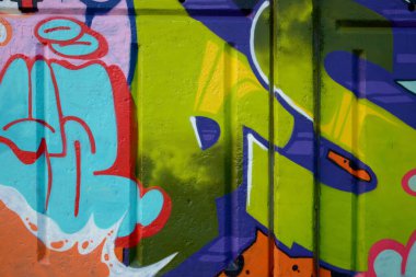 Duvarında parlak aerosol çizgileri olan grafiti resimlerinin renkli arka planı. Eski moda sokak sanatı sprey boya kutularından yapılmış. Çağdaş gençlik kültürü arka planı