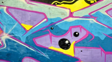 Duvarında parlak aerosol çizgileri olan grafiti resimlerinin renkli arka planı. Eski moda sokak sanatı sprey boya kutularından yapılmış. Çağdaş gençlik kültürü arka planı