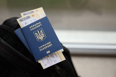 Siyah turistik sırt çantası üzerinde uçuş biletleri olan iki Ukrayna biyometrik pasaportu.