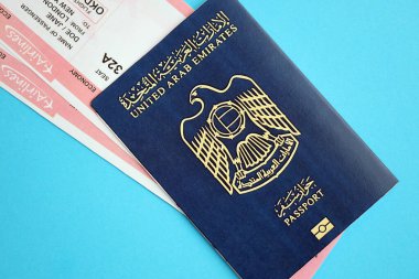 Mavi arka planda uçak biletleri olan Mavi Birleşik Arap Emirlikleri pasaportu. Turizm ve seyahat kavramı