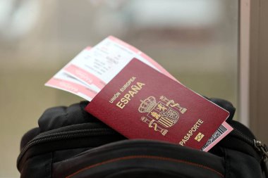 Avrupa Birliği 'nin turistik sırt çantasındaki uçak biletleriyle birlikte kırmızı İspanyol pasaportu. Turizm ve seyahat kavramı