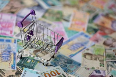 Farklı para birimlerinin banknotlarında süpermarket tramvayı. Dünya çapında alışverişin arka planı