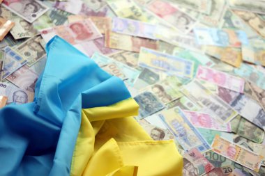 Farklı para birimlerinin banknotlarında Ukrayna bayrağı. Ukrayna 'daki savaş finansmanı ve askeri destek fiyatlarının geçmişi