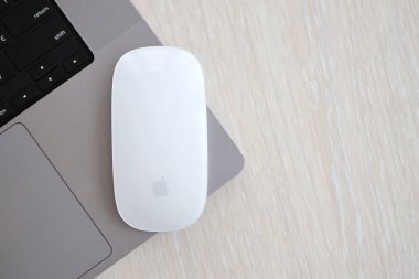 KYIV, UKRAINE - 27 Kasım 2023 Apple Magic Mouse 3. Nesil Gri MacBook 2021 ile yakın plan
