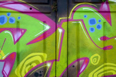 Duvarında parlak aerosol çizgileri olan grafiti resimlerinin renkli arka planı. Eski moda sokak sanatı sprey boya kutularından yapılmış. Çağdaş gençlik kültürü arka planı