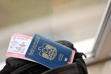 Mavi Birleşik Arap Emirlikleri pasaportu ve turistik sırt çantasında uçak biletleri. Turizm ve seyahat kavramı