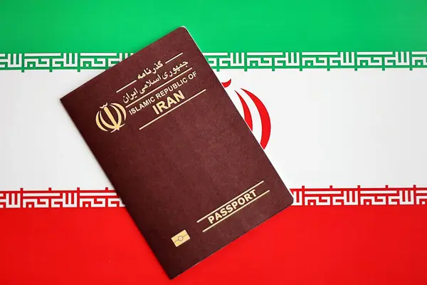 stock image Red Islamic Republic of Iran passport on national flag background close up. Tourism and citizenship concept