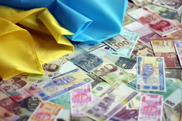 Farklı para birimlerinin banknotlarında Ukrayna bayrağı. Ukrayna 'daki savaş finansmanı ve askeri destek fiyatlarının geçmişi