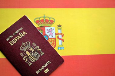 Red Spanish passport of European Union on national flag background close up. Tourism and citizenship concept clipart
