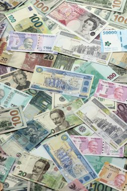 Farklı para birimlerinden bir sürü banknot. Rastgele para akışının arka planı kapanıyor.