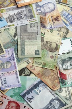 Farklı para birimlerinden bir sürü banknot. Rastgele para akışının arka planı kapanıyor.