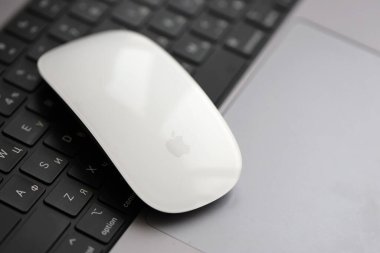 KYIV, UKRAINE - 27 Kasım 2023 Apple Magic Mouse 3. Nesil Gri MacBook 2021 ile yakın plan