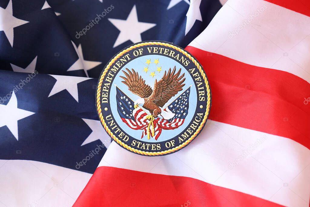 KYIV, UKRAINE - MARCH 9, 2024 US Department of Veteran Affairs seal on United States of America flag close up