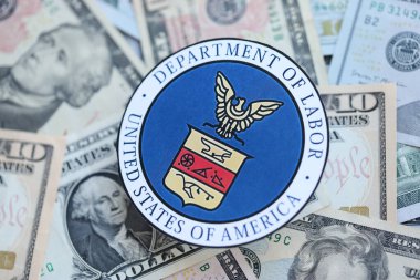 KYIV, UKRAINE - MARCH 9, 2024 US Department of Labor seal on many US dollar bills close up clipart