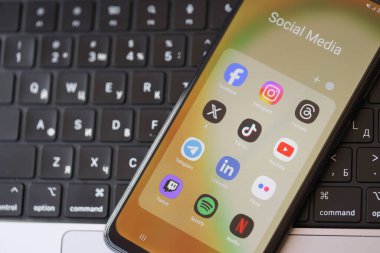 KYIV, UKRAINE - Galaksi A04 'te 28 Şubat 2024 Sosyal Medya simgeleri grubu MacBook klavyesinde akıllı telefon görüntüsü