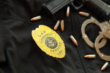 KYIV, UKRAINE - 9 Mart 2024 ABD Emniyet Teşkilatı rozeti üzerinde silah, mermi ve kelepçe var.