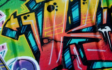Duvarında parlak aerosol çizgileri olan grafiti resimlerinin renkli arka planı. Eski moda sokak sanatı sprey boya kutularından yapılmış. Çağdaş gençlik kültürü arka planı