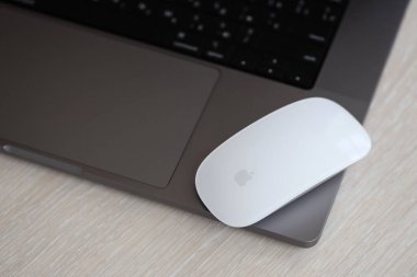 KYIV, UKRAINE - 27 Kasım 2023 Apple Magic Mouse 3. Nesil Gri MacBook 2021 ile yakın plan