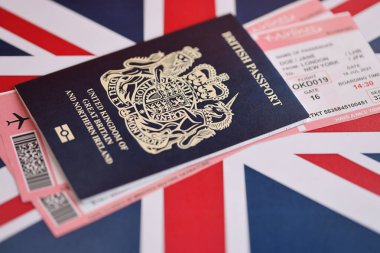 Ulusal arkaplanda uçak biletleri olan mavi İngiliz pasaportu. Turizm ve seyahat kavramı