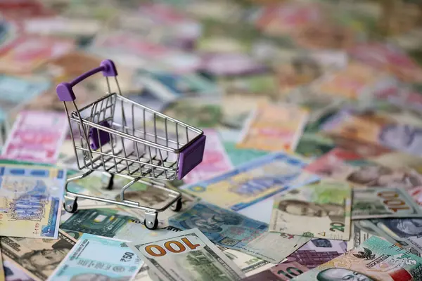 Farklı para birimlerinin banknotlarında süpermarket tramvayı. Dünya çapında alışverişin arka planı