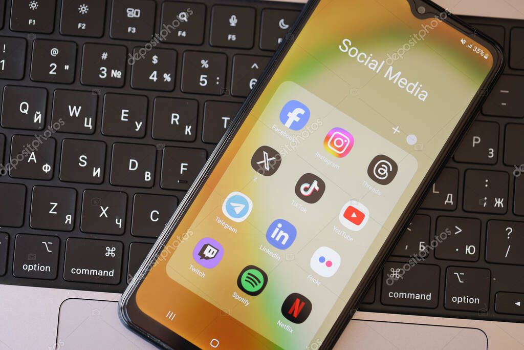 KYIV, UKRAINE - FEBRUARY 28, 2024 Social Media icons group on Galaxy A04s smartphone display on MacBook keyboard