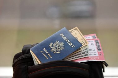 Mavi Amerika Birleşik Devletleri pasaportu ve turistik sırt çantasındaki uçak biletleri. Turizm ve seyahat kavramı