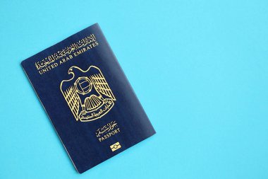 Blue United Arab Emirates passport on blue background close up. Tourism and citizenship concept clipart