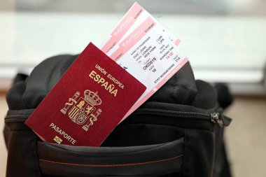 Avrupa Birliği 'nin turistik sırt çantasındaki uçak biletleriyle birlikte kırmızı İspanyol pasaportu. Turizm ve seyahat kavramı