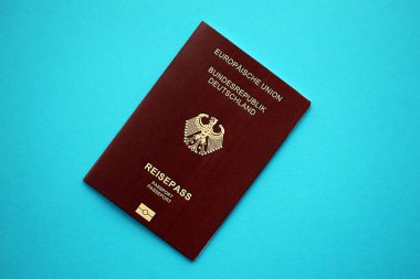 Avrupa Birliği 'nin kırmızı Alman pasaportu mavi arka planda. Turizm ve vatandaşlık kavramı