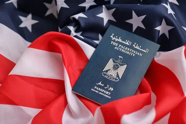 stock image Blue Palestinian Authority passport on United States national flag background close up. Tourism and diplomacy concept