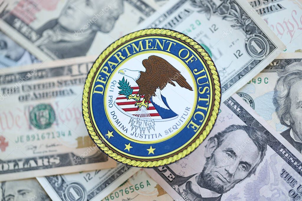 KYIV, UKRAINE - MARCH 9, 2024 US Department of Justice seal on many US dollar bills close up