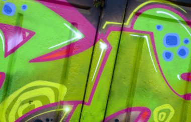 Duvarında parlak aerosol çizgileri olan grafiti resimlerinin renkli arka planı. Eski moda sokak sanatı sprey boya kutularından yapılmış. Çağdaş gençlik kültürü arka planı