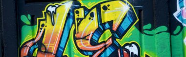 Duvarında parlak aerosol çizgileri olan grafiti resimlerinin renkli arka planı. Eski moda sokak sanatı sprey boya kutularından yapılmış. Çağdaş gençlik kültürü arka planı