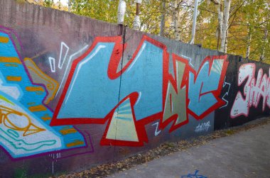 Sokak sanatı kültürü tarzında boya lekeleriyle süslenmiş eski duvar. Duvarında parlak aerosol çizgileri olan graffiti resimlerinin renkli arka planı. Renkli arkaplan dokusu