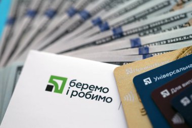 TERNOPİL, UKRAINE - 7 Temmuz 2023 Privatbank yeni bankacılık kartları ve masada para. Zarftaki yeni kart kapat