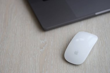 KYIV, UKRAINE - 27 Kasım 2023 Apple Magic Mouse 3. Nesil Gri MacBook 2021 ile yakın plan