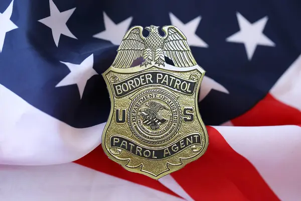 stock image KYIV, UKRAINE - MARCH 9, 2024 US Border Patrol Agent badge on United States of America flag close up