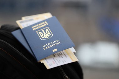 Siyah turistik sırt çantası üzerinde uçuş biletleri olan iki Ukrayna biyometrik pasaportu.